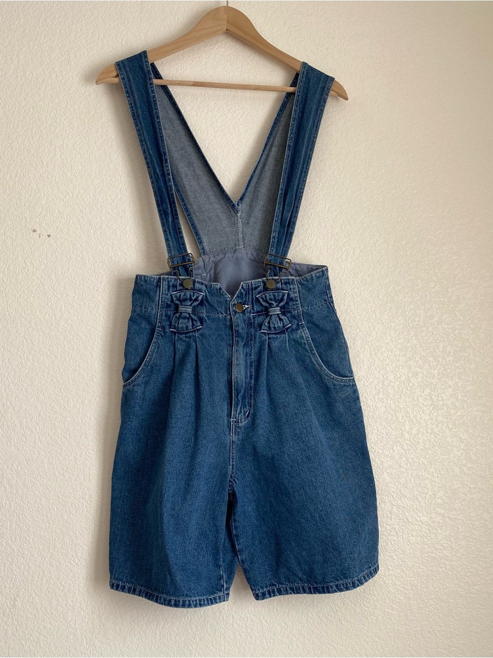 Vintage high-waisted denim suspender shorts with decorative bow accents,5/6